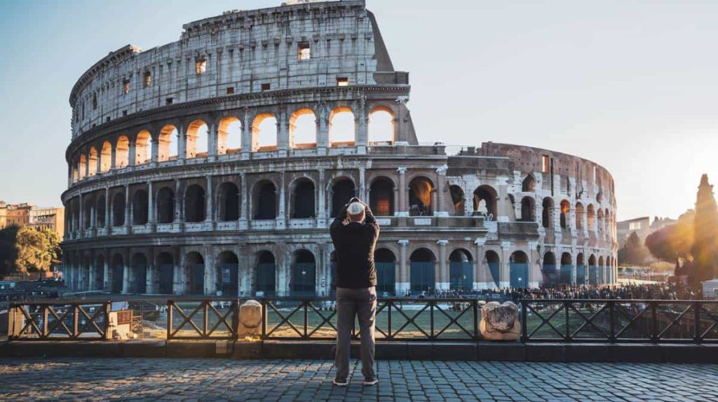 Home 87 Ancient Colosseum in Rome with blue sky in the background.